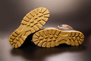 fluted sole of winter brown leather men's shoes on a black background.