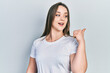 © Krakenimages.com - Young hispanic girl wearing casual white t shirt pointing thumb up to the side smiling happy with open mouth