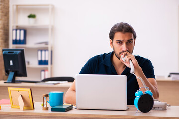 Young male employee working at workplace