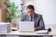 © Elnur - Young male employee unhappy with excessive work in the office