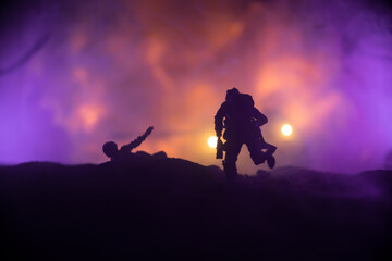 Wall Mural - War Concept. Military silhouettes fighting scene on war fog sky background, World War Soldiers Silhouette Below Cloudy Skyline At night. Battle in ruined city. Selective focus