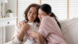 © ChayTee - Candid attractive beautiful mum sit at cozy sofa couch living room in family moment grown child kid celebrate joy good warm time kiss relationship with retired overjoy lady girl health life insurance.