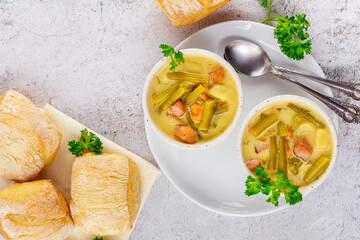 Wall Mural - Homemade creamy vegetable soup on white bowl with dinner roll.