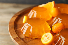 Plate With Tasty Orange Jelly On Wooden Background, Closeup