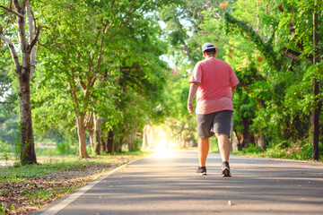 Wall Mural - Fat man exercising By walking to burn fat And run slowly to exercise in the park