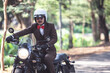 Rider riding modern classic motorcycle with suit look like gentleman for men campaign. Rider happy in freedom lifestyle travel by motorbike.