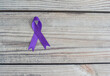 World Cancer Day. International Overdose Awareness Day. The purple ribbon on the wooden table