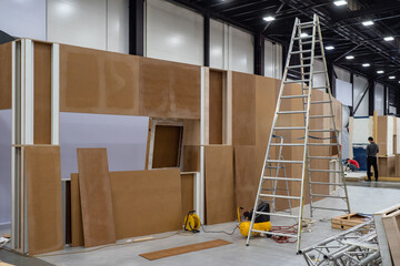Poster - stepladder and plywood structures in the exhibition hall. preparation for the exhibition. constructi