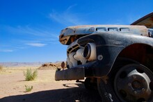 Front Of An Old Rusty Car Wreck In The Namibian Desert On A Sunny Day With Blue Sky And Few Clouds