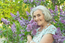 Happy  Senior Beautiful Woman With Lilacs