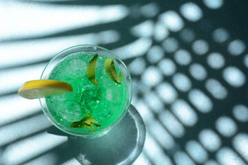 Glass of cocktail green fairy with lemon and mint leaves. Sweet refreshing mint liqueur, with ice and absinthe, rum, Ice cubes and Vodka