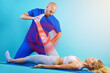 © alphaspirit - Girl performs exercises with a physiotherapist. Cyan background