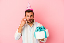 Young Caucasian Man Celebrating His Birthday Isolated On Pink Background Showing A Disappointment Gesture With Forefinger.