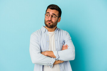 Wall Mural - Young caucasian man isolated on blue background dreaming of achieving goals and purposes