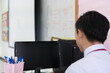 © smolaw11 - Asian Male teacher wearing white face mask safety during COVID-19 pandemic coronavirus epidemic using computer in front classroom. Back to school after lockdown from pandemic. Healthcare on Education