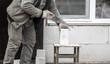 © schankz - A worker cuts a brick with a saw.