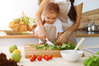 © volha_r - Happy woman and her daughter making healthy vegan salad and snacks for family feasting in sunny kitchen. Christmas, New year, Thanksgiving, Anniversary, Mothers Day. Healthy meal cooking concept