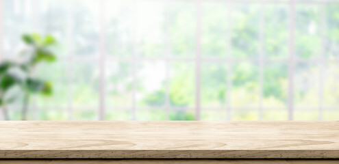 Fototapete - wooden table background with blur window see through garden at home.Mockup banner space for product display for advetising at online media
