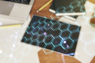 Poster - Creative abstract wireless technology hologram with hexagon and modern digital tablet on desktop on background, top view, artificial intelligence and machine learning concept. Multi exposure