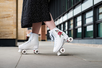 Side view of young woman on black skirt roller skating.