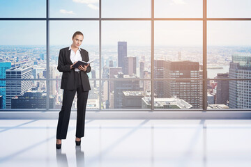 Sticker - Attractive businesswoman wearing formal suit holding her notes. Panoramic office on background with financial downtown city view.