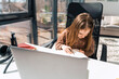 © Andrii  - Cute little schoolgirl studies at home near laptop