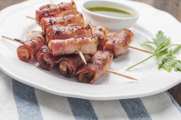 Sticker - Plate of skewered bacon-wrapped prawns on a wooden stick served with sauce and parsley