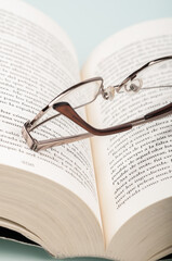 Canvas Print - Vertical close-up shot of optical glasses on a open book