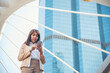 © aFotostock - Business woman using smartphone shopping online, call, texting message internet technology lifestyle. Asian woman using cellphone walking on city street. Smart phone smart confident woman modern city