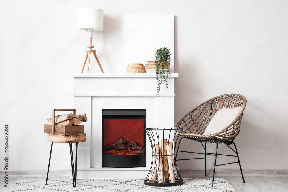 Modern fireplace and armchair near light wall