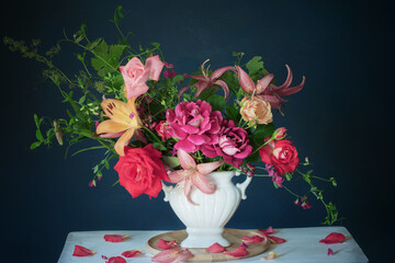 bouquet of summer flowers in vase on vintage white wooden shelf on dark background