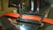 Industrial Sewing Machine. In The Stitching Of The Orange Textile Belt