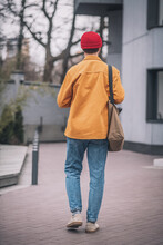 Man In An Orange Jacket Walking Down The Street