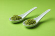 Ceramic spoons with wasabi on green background