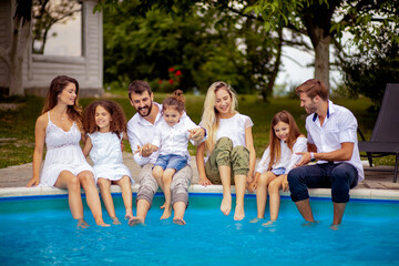 Wall Mural - Large group of people sitting by the swimming pool.