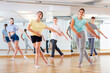 © JackF - Diligent friendly smiling teenagers learn dance movements in dance class