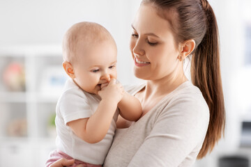 Wall Mural - family, motherhood and people concept - happy mother with little baby daughter at home