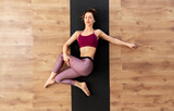 fitness, sport and healthy lifestyle concept - woman doing yoga and stretching on floor at studio
