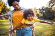 © liderina - African American mother and daughter running trough park. Focus on little girl.