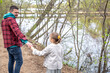 © puhimec - Little girl with dad are walking in the spring forest, holding hands.