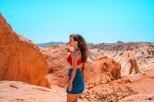 Portrait Of A Happy Brunette Woman In The Valley Of Fire In Nevada Overlooking A Desert Landscape