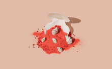 Creative Seashell Arrangement With Red Sand On Pastel Beige Background.