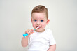 © Гульнара Мандрыкина - a small child with blue eyes holds toothbrushes in his hands
