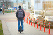 © Tricky Shark - Man ride on electric unicycle on city street. Mobile portable individual transportation vehicle. Mono wheel - personal vehicle for transportation. Boy with backpack on electric mono-wheel (EUC)