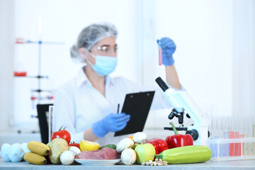Wall Mural - fresh vegetables, fruits, meat on table and scientist proceeding quality control in laboratory
