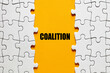 The word coalition between the jigsaw puzzle pieces. Alliance, cooperation and collaboration in business or politics