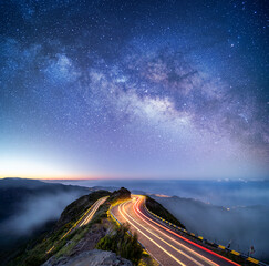 astrophotography shot of hairpin turn with galactic core milky way rising on madeira island, portuga