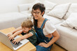 © (JLco) Julia Amaral - Woman and her son at home using a laptop