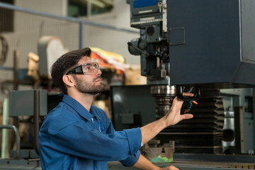 Male engineer worker. Male factory worker working or maintenance the machine in the industrial factory with wear safety uniform and helmet