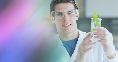 Poster - Composition of male scientist holding beaker with plant in laboratory with pink motion blur